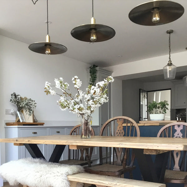 A wooden, simplistic dining room interior with industville lighting