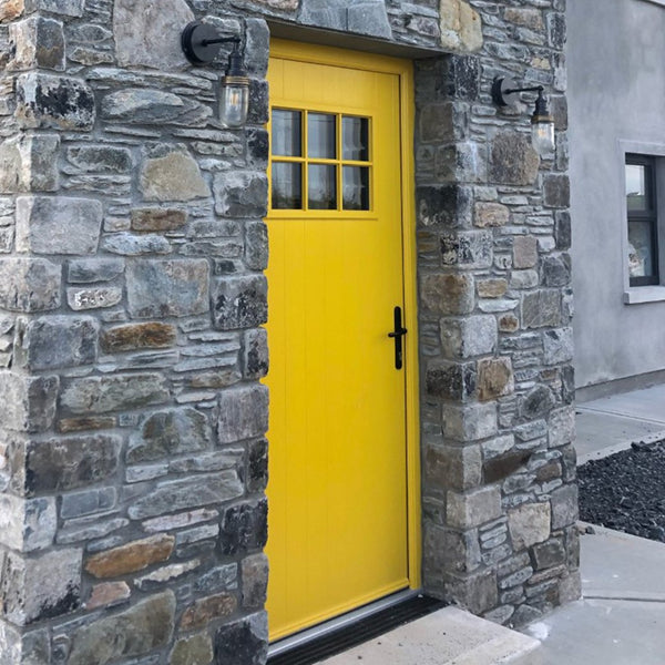 Mustard coloured door outside with industrial lighting