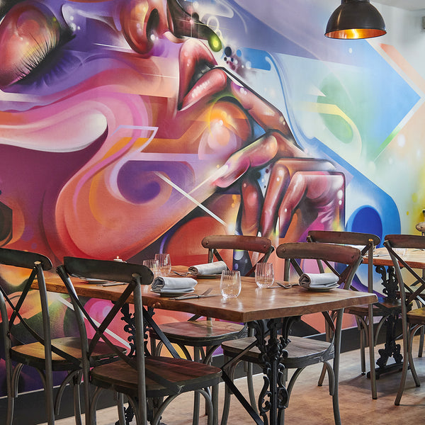 Graffiti wall art and vintage ceiling lights in a restaurant interior 