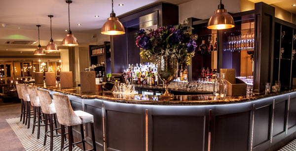 Velvet chairs and industrial lights in a bar interior