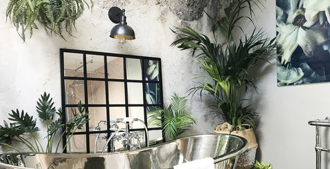 jungle inspired bathroom interior with industrial wall light