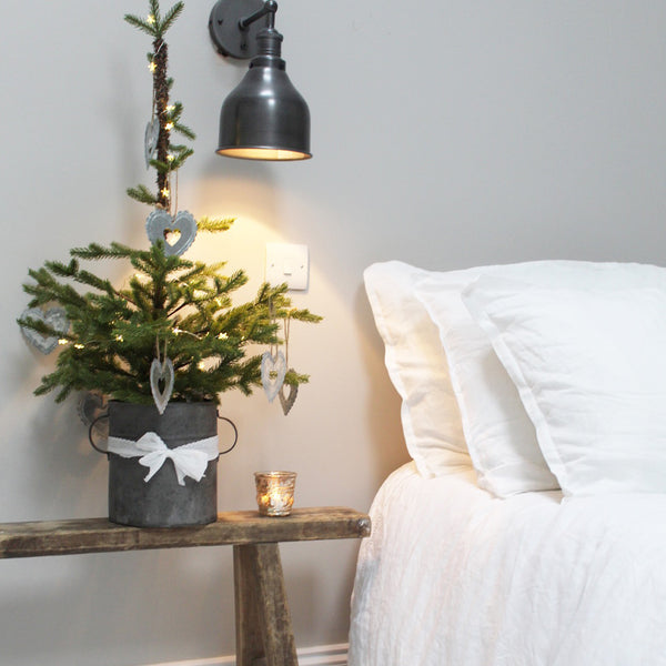 Vintage light shining on Christmas tree next to bed