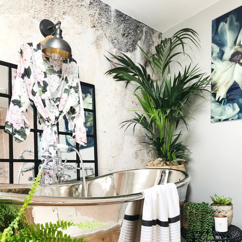 A metallic bathroom with plants, large mirror and wall light by Industville