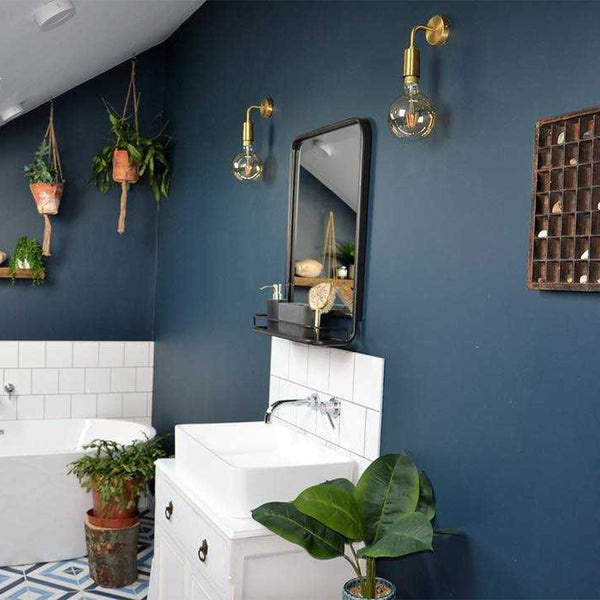 Bathroom with blue walls and brass wall lights
