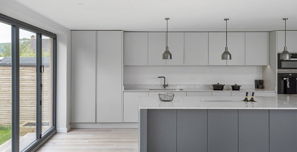 Open plan interior with grey concrete accents and trio of pewter industrial lights