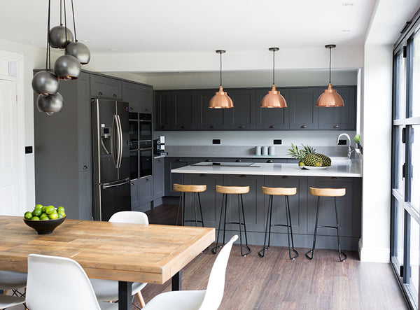 Open-plan grey kitchen interior with industrial lights