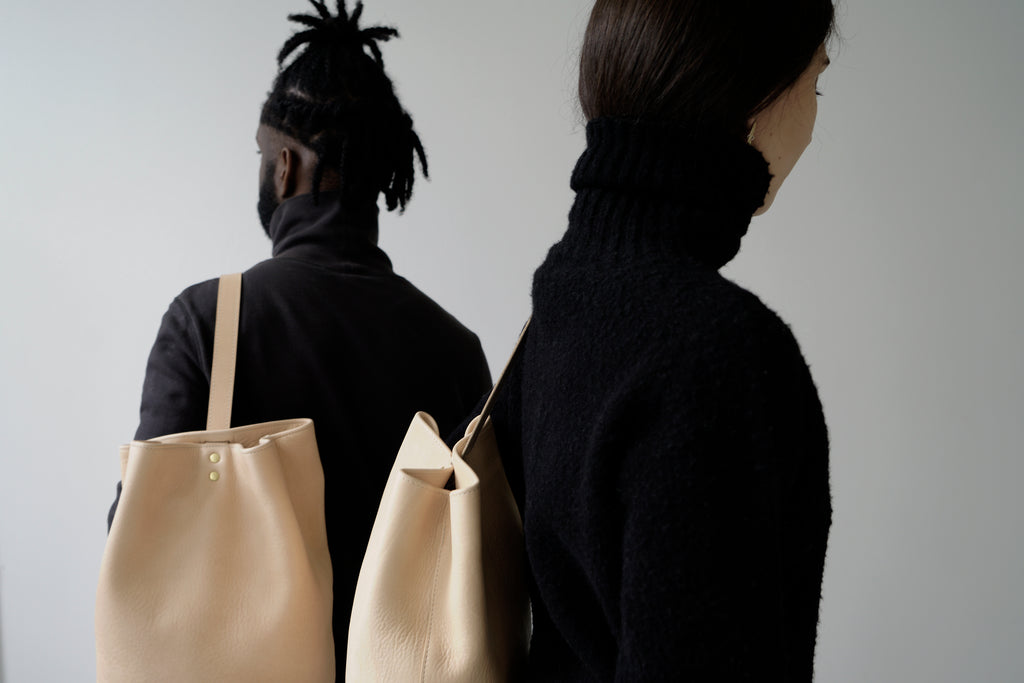 male model and female model with leather backpacks