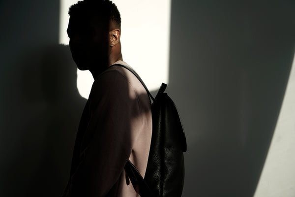 Male model in the sunlight wearing leather backpack