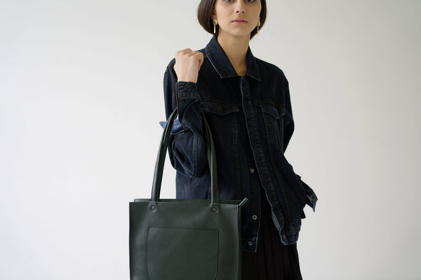 female model holding a leather tote bag