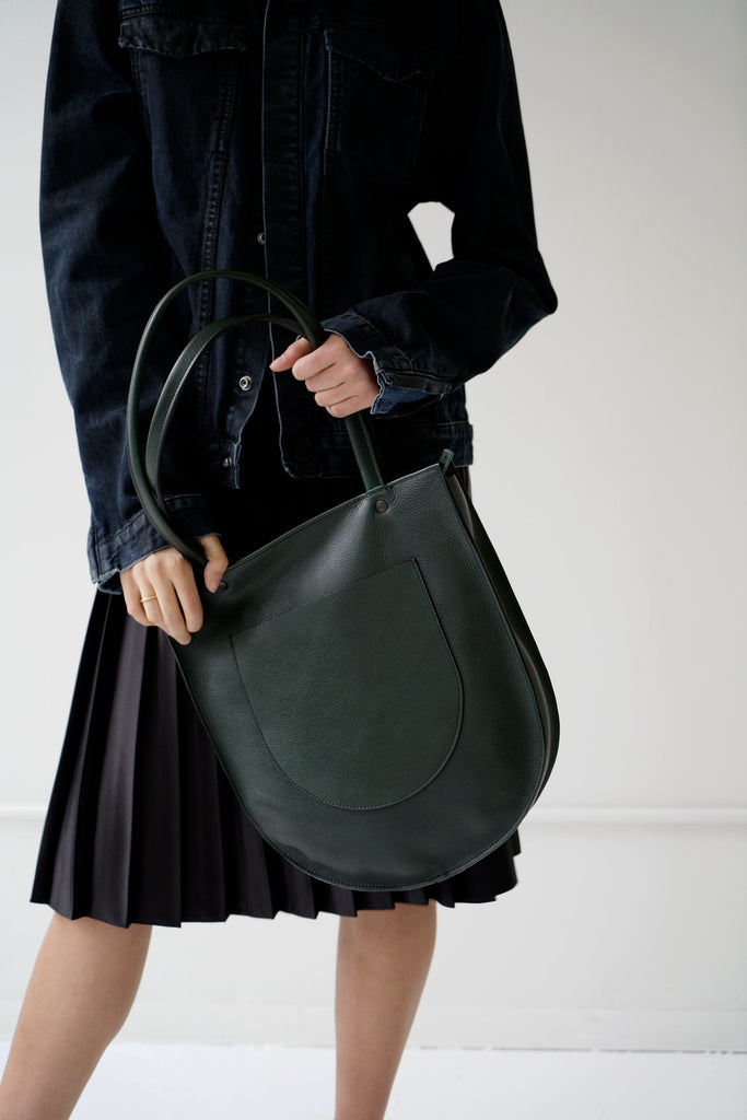 Female model with green leather bag