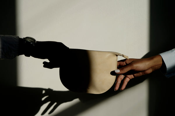 Models holding a leather pouch in the sunglight