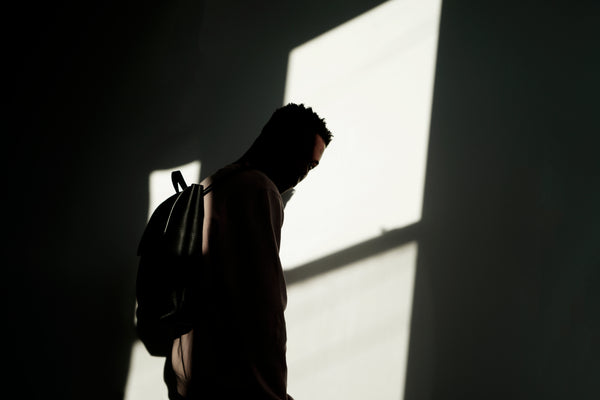 Male model in the sunlight wearing a leather backpack