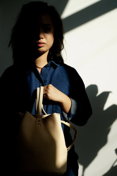 Female model in the sun wearing a leather backpack