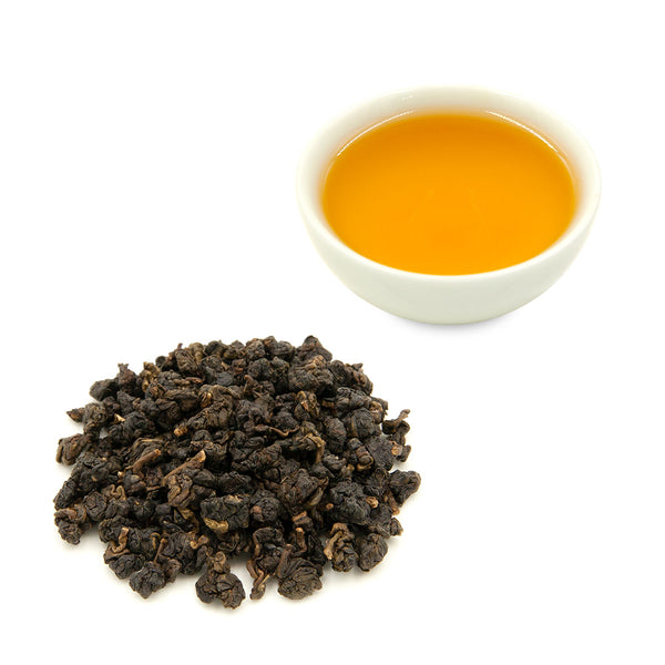 Brewed Dong Ding Oolong Tea in white tea cup and dry tea leaves