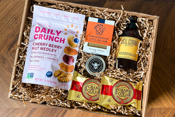 Wellness at Home gift Box from Batch + Nashville Scene.  Limited edition gift box includes Local Economy Liquid Hand Soap, Grab the Gold Protein Snacks, Daily Crunch Cherry Berry Nut Medley, Little Seed Farm Jackalope Rompo Beer Bar Soap, TruBee Wax Rub.