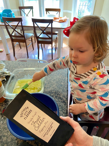 toddler making Southern City Flavors cobbler from Batch