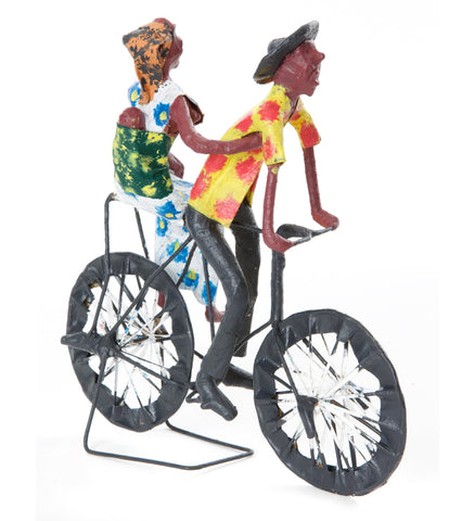 Bicycle art, Zambian papier-mache of a father, mother, and swaddled baby riding on a bike, wearing colorful handpainted clothes