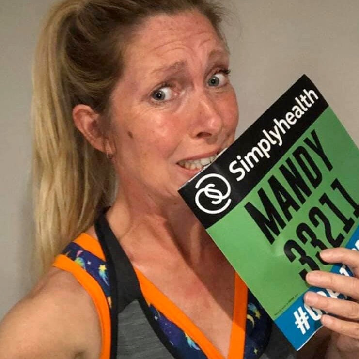 Mandy wearing her running gear and Molke Space bra looking apprehensive and holding her running label.
