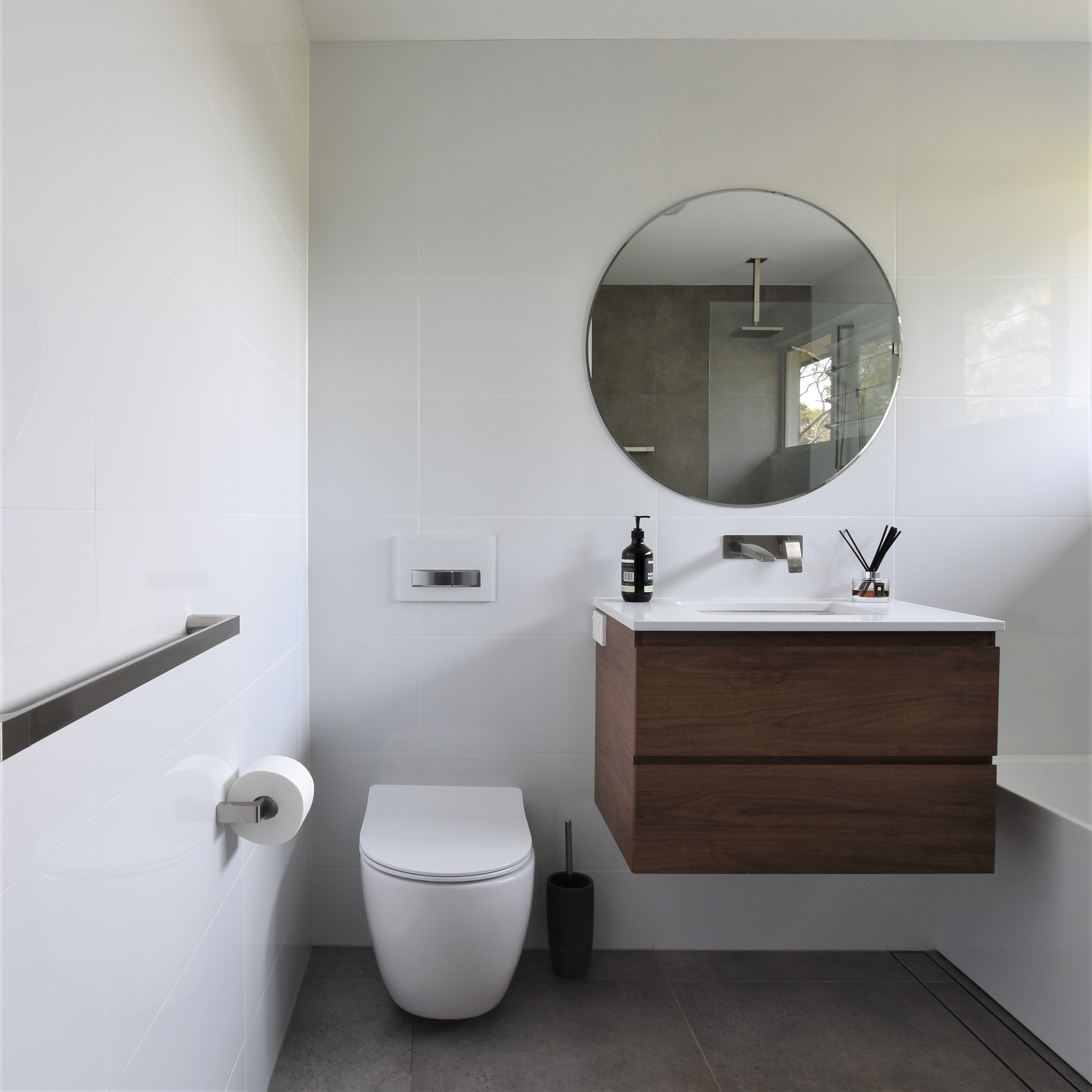 This bathroom features a toilet with a cistern behind the wall, making it better for cleaning