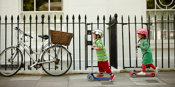 Kids scooting on the footpath