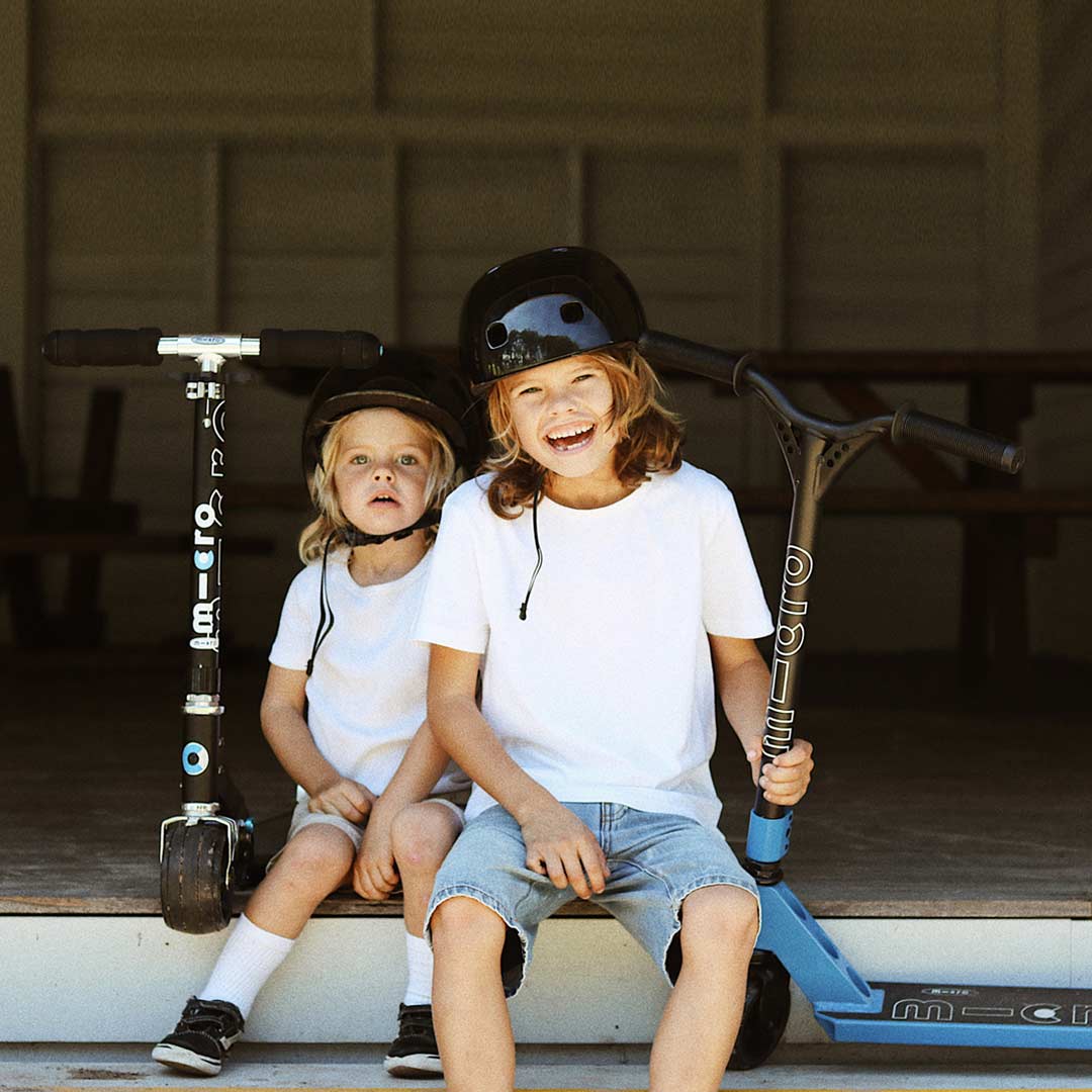 Big brother and little brother ready for school with their scooters