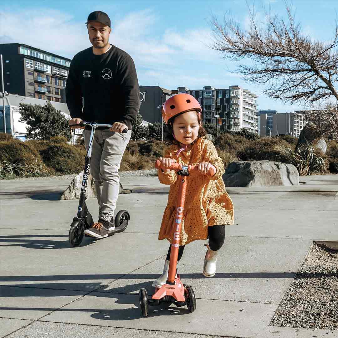 little girl and her dad scooting to school