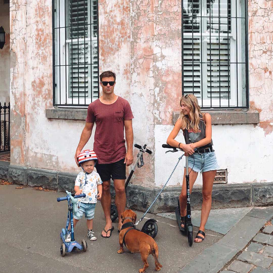Parents & kid with Micro scooters and dog