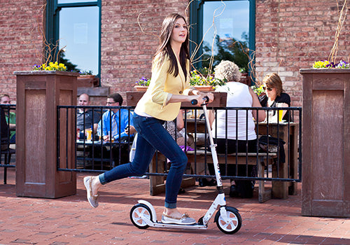 Woman using kick scooter to travel