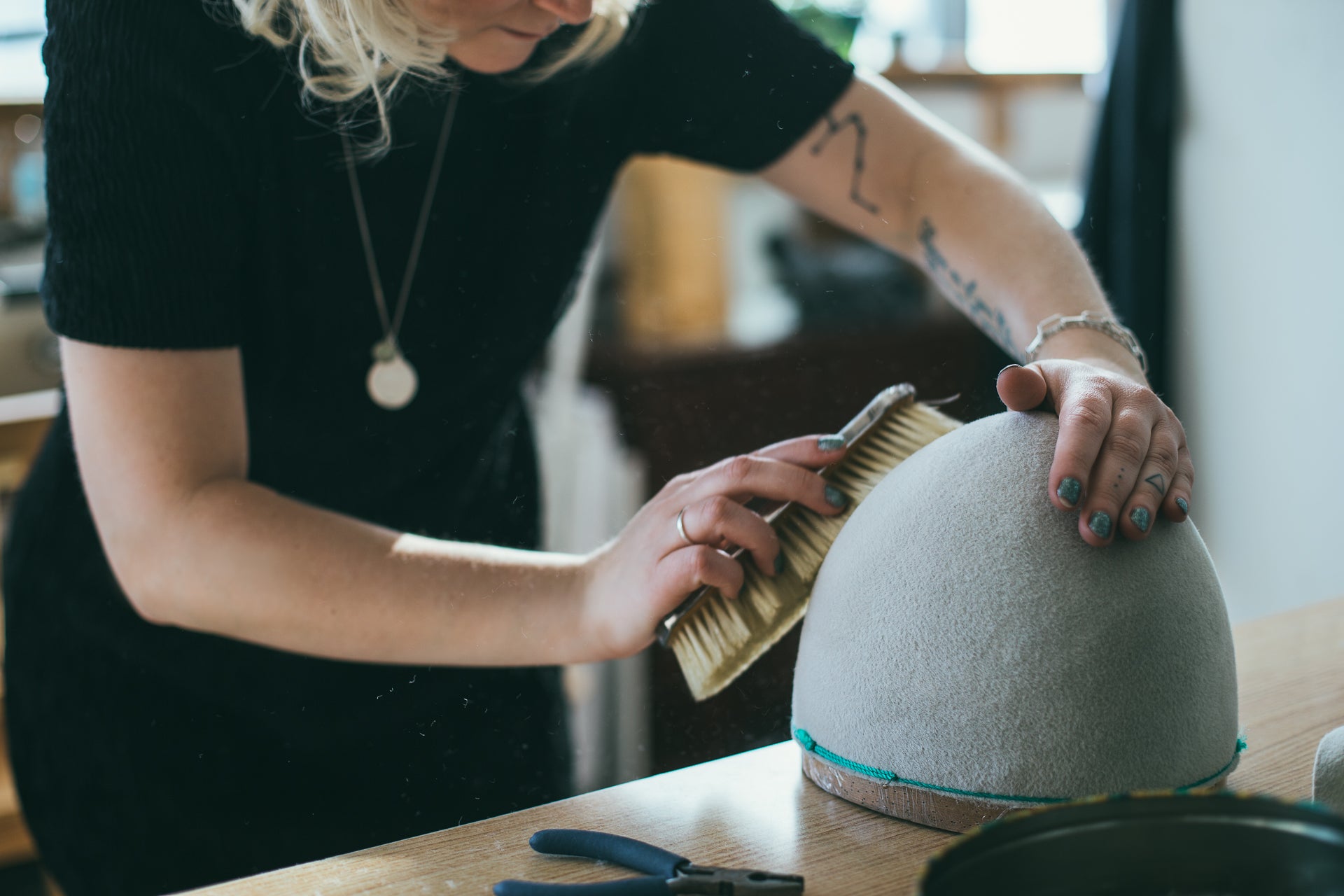 Making a hat, brushing dust off a hat