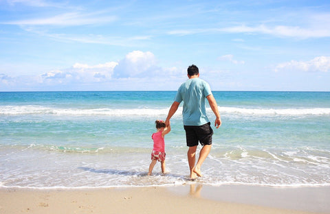 Father and Daughter Walking on A Beach