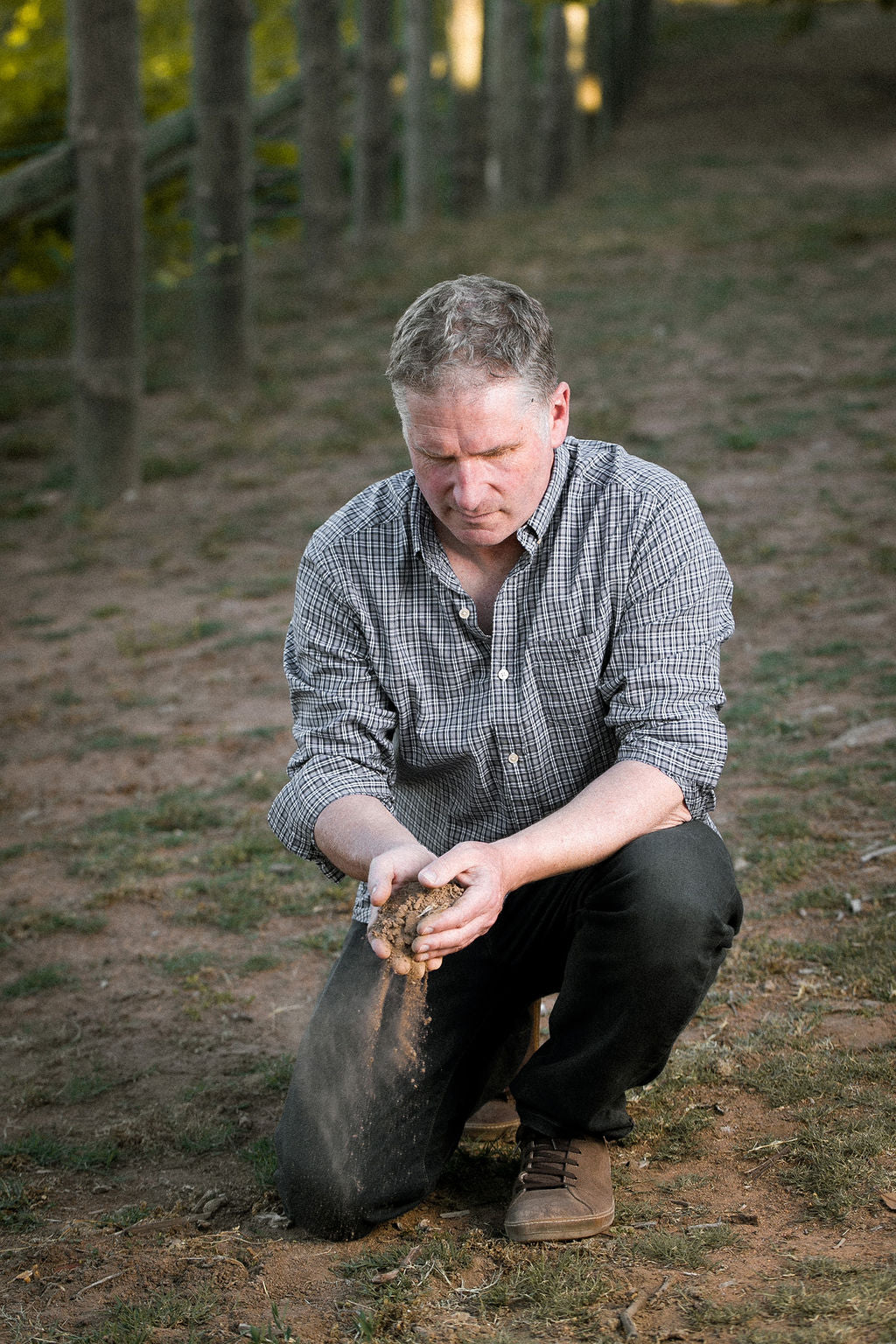 Winemaker Alex McKay examines the soil in the vineyard.