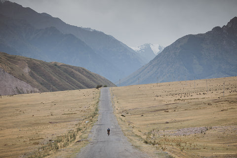 A man in the middle of the mountains riding his bike