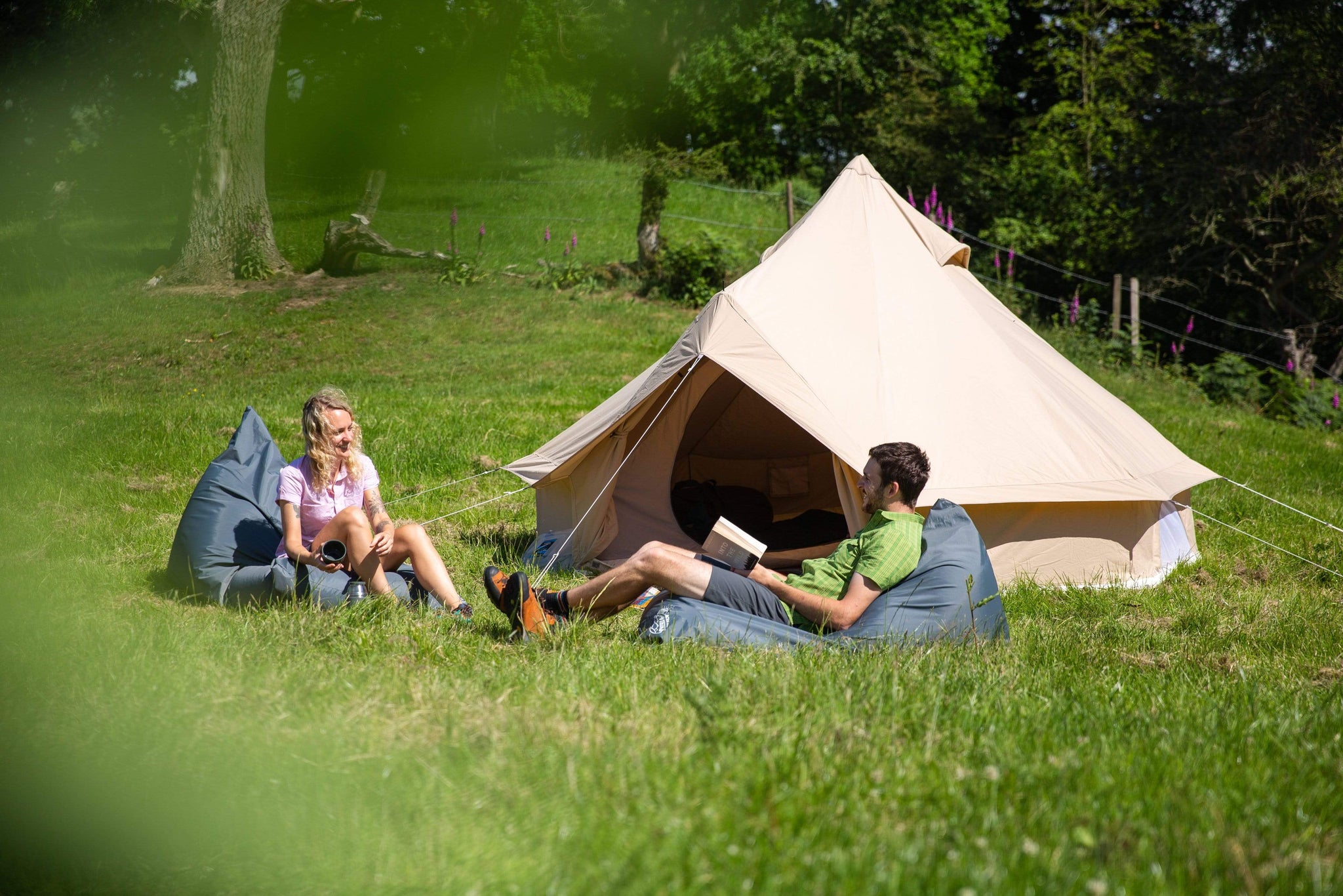 Relaxing in the sunshine outside the Roundhouse organic cotton bell tent on Bean Mountain giant outdoor bean bags
