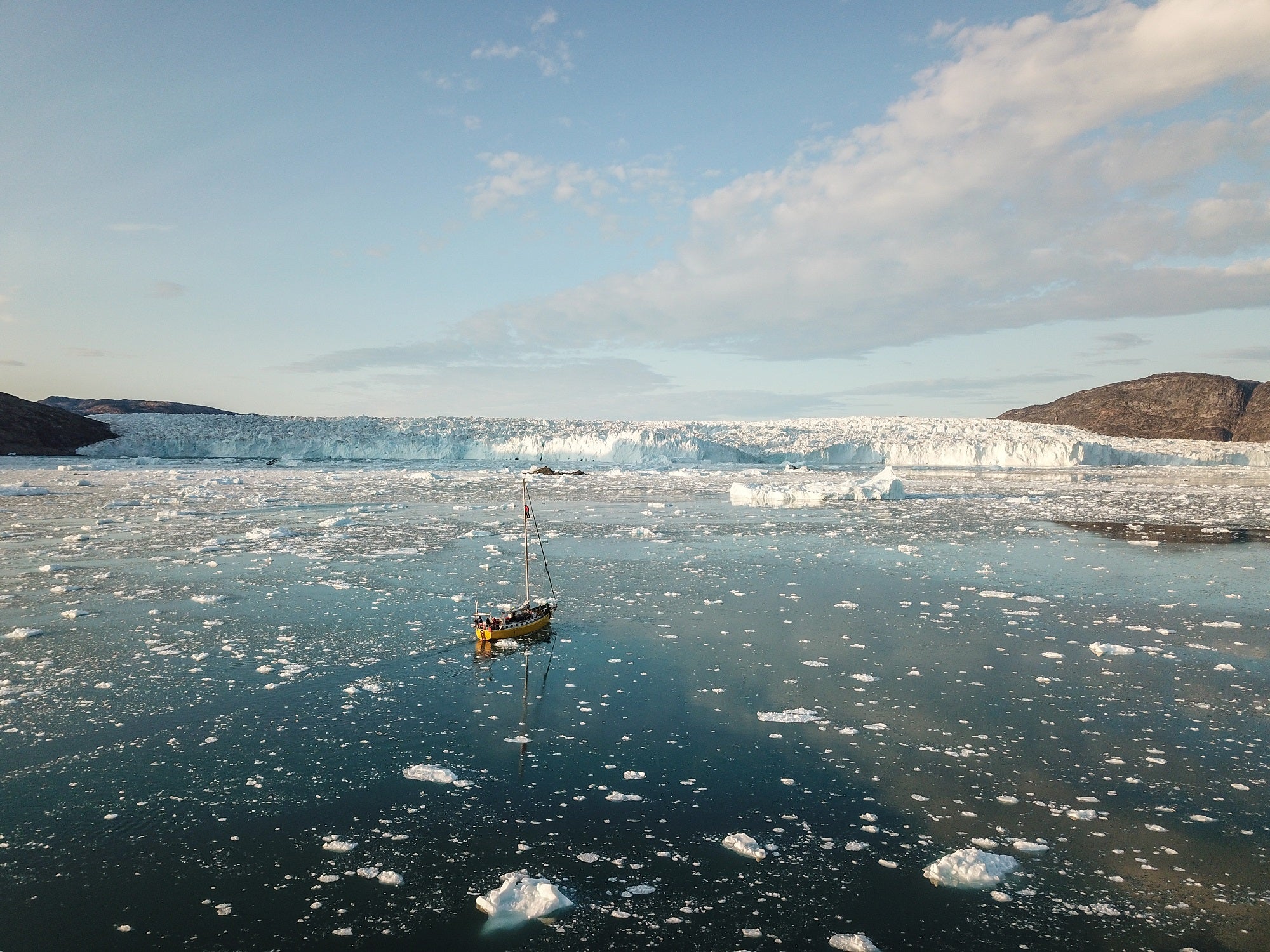 sailboat navigating a field of icebergs