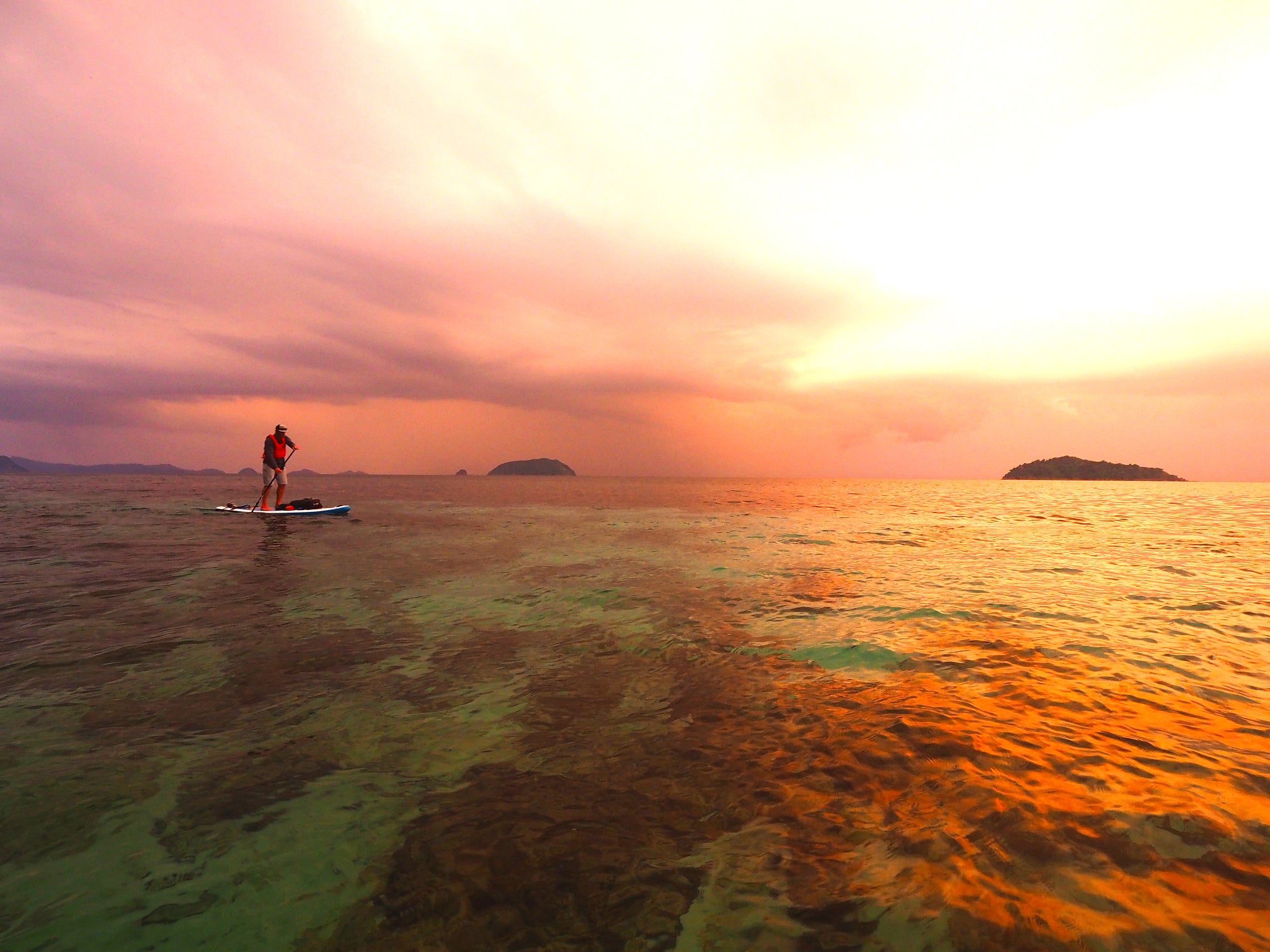 man paddle boarding during a sunset in Myanmar