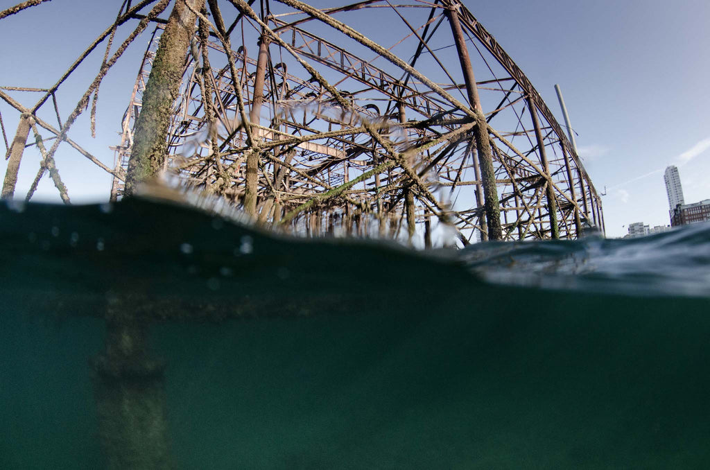 Partially underwater photograph of derelict Brighton West Pier, blue skies