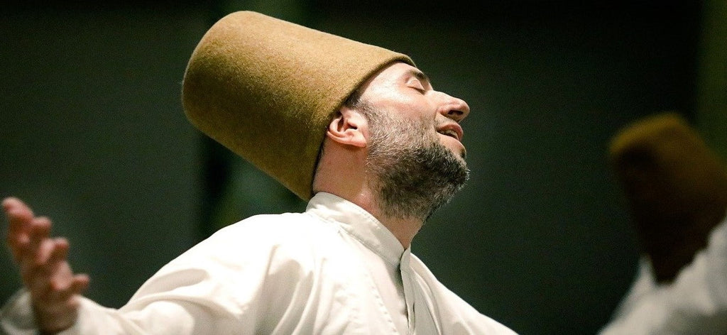 Pratiquant de l'ésotérisme soufi en train de danser en tournant sur lui-même au cours d'une danse traditionnelle