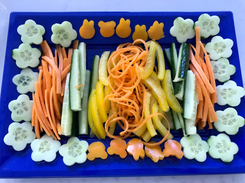 Cucumber cut into flowers and stars, grated carrot and yellow pepper batons