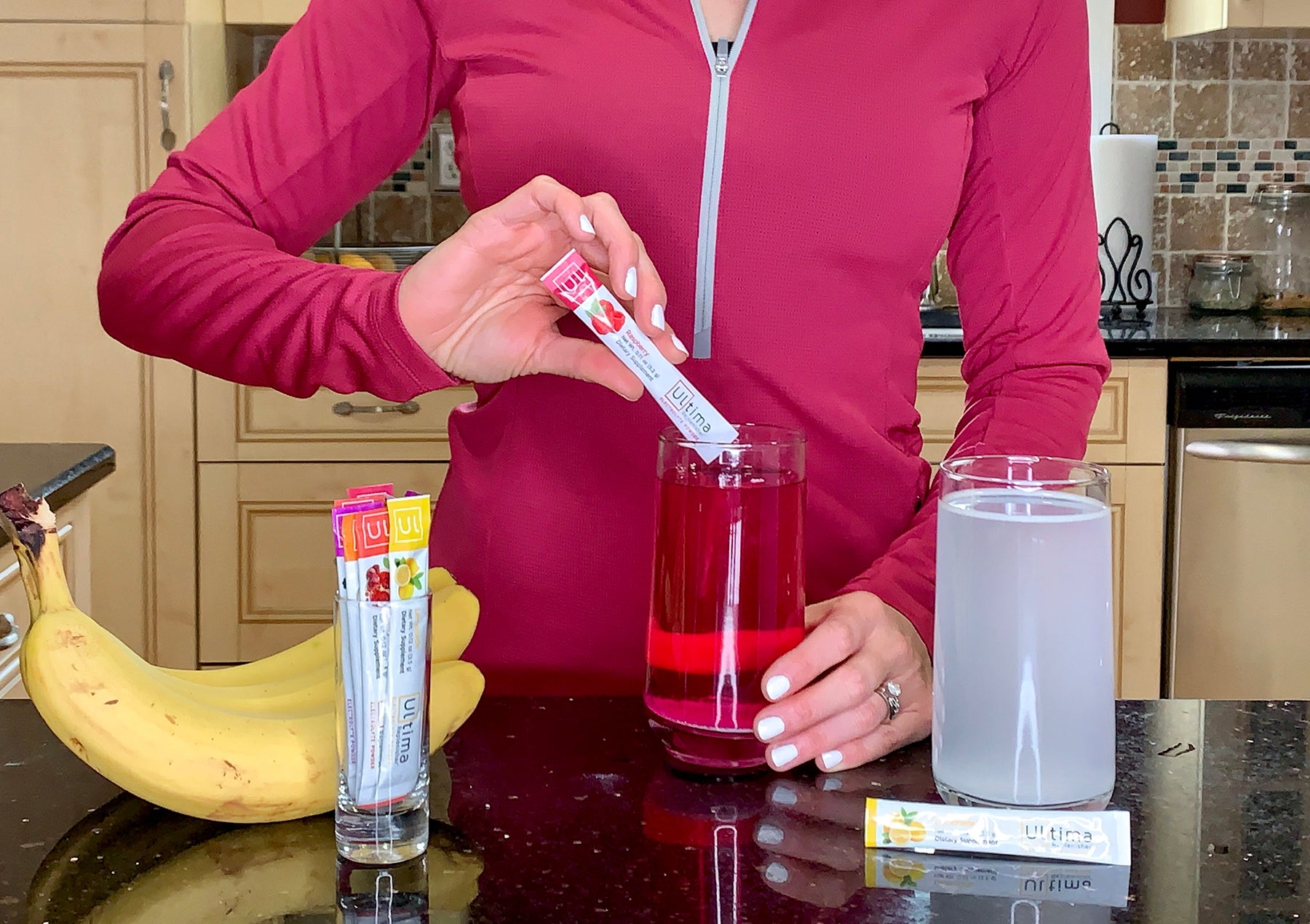 Woman mixing an electrolyte drink with Ultima Replenisher Stickpacks