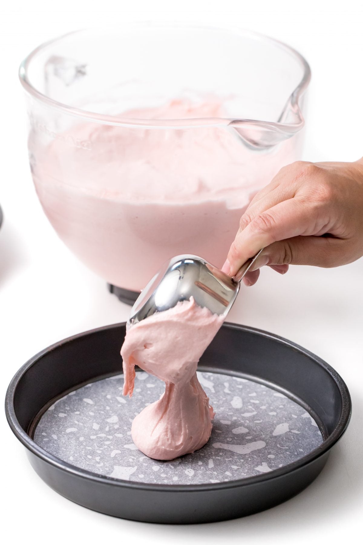 VERSER LA PÂTE À GÂTEAU DANS UN MOULE TAPISSÉ DE PAPIER PARCHEMIN SUR LE FOND.