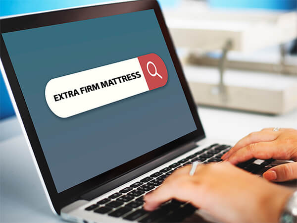 a person browsing through extra firm mattresses online
