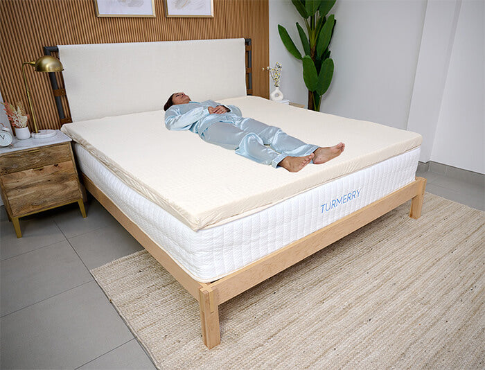 A woman sleeping on a 1 inch breathable queen topper with cover