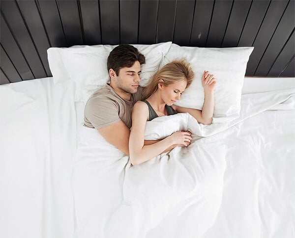 Two people sleeping on queen mattress