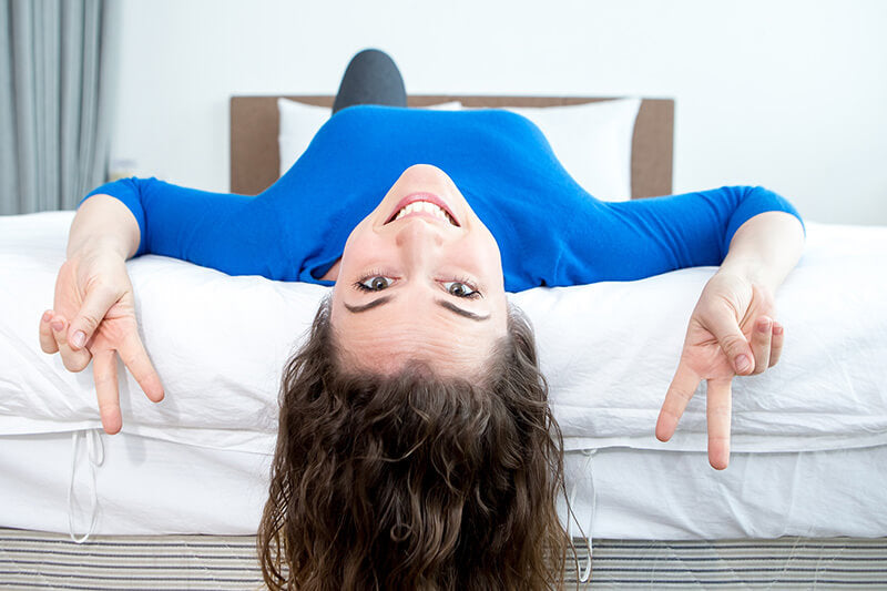 a woman lying down on a bed to see how the mattress feels