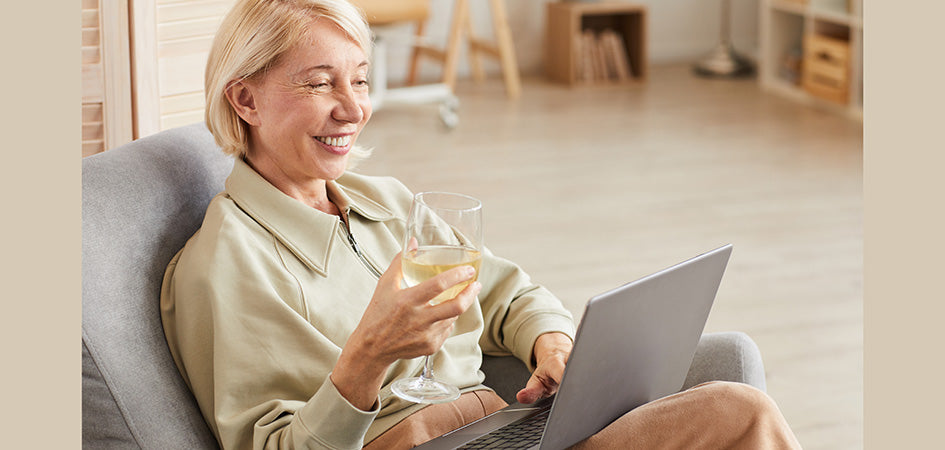 Elderly woman smiling having a glass of wine. full spectrum cbd oil for sale. cbd oil for anxiety for sale.
