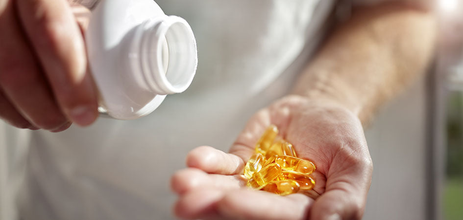 CBD capsules poured into a human hand. How much cbd oil for pain? Does cbd oil help with pain?