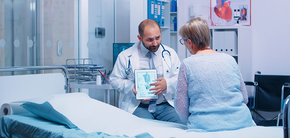 Doctor teaching patient how cbd oil works for back pain relief.