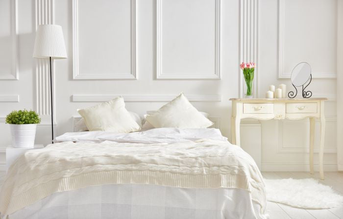 Fresh bed linen in white bedroom during spring time.