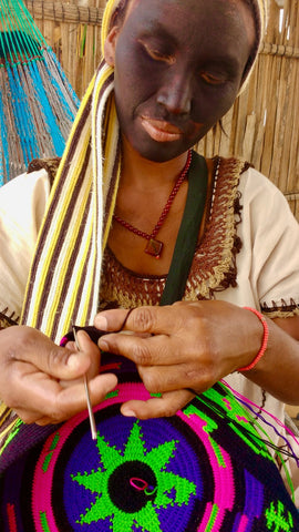 Adela, a Wayuu Artisan, works on a bag.
