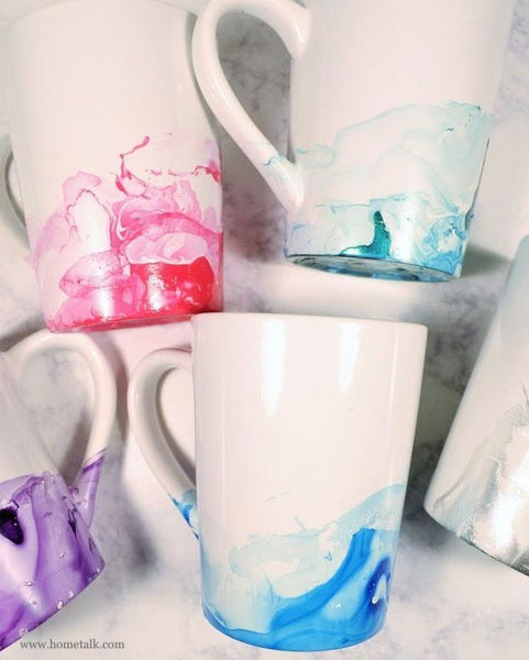Close up image of 5 white mugs with marbled effect on bottoms
